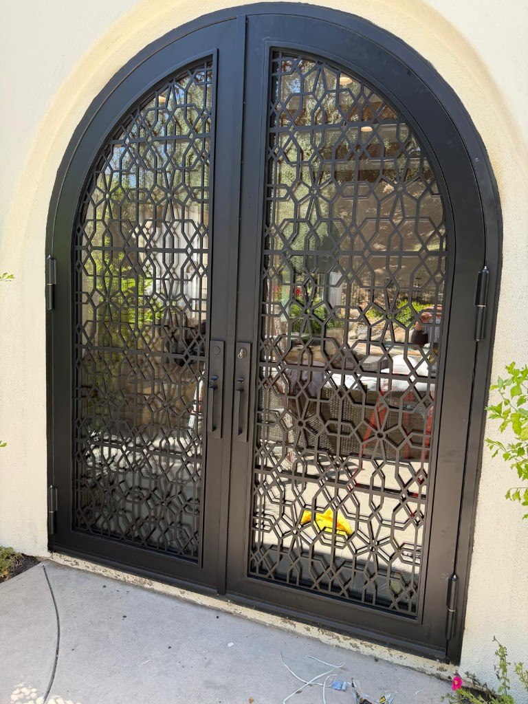 Arched steel entry doors with geometric iron pattern
