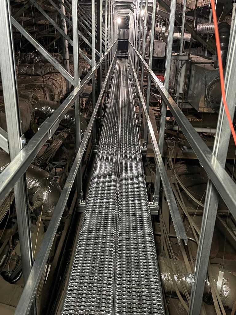 Galvanized steel catwalk with handrails in a commercial mechanical space