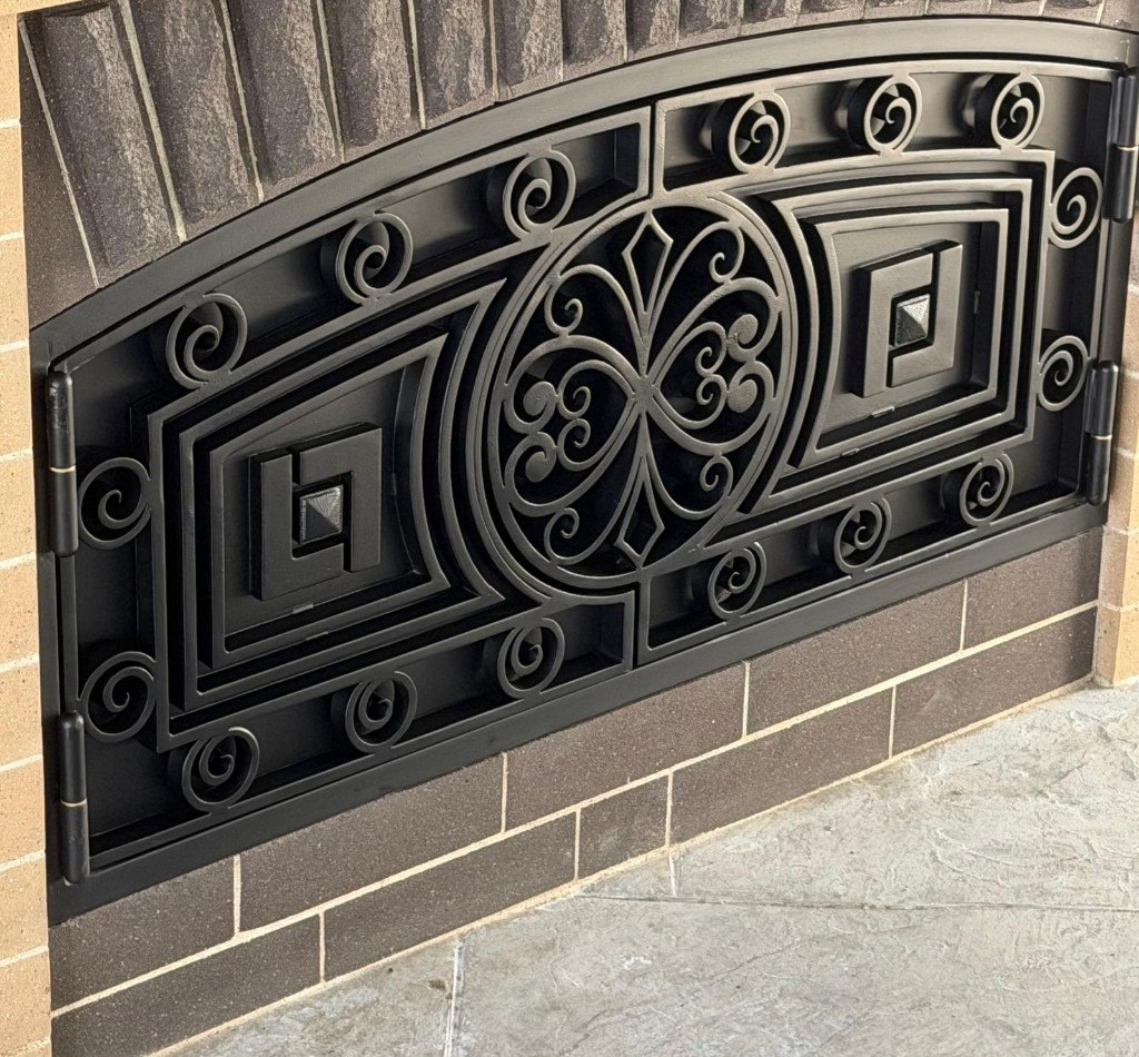 Ornamental iron gate with scrollwork and geometric panels