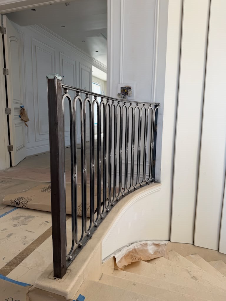 Polished iron landing railing with oval loop balusters