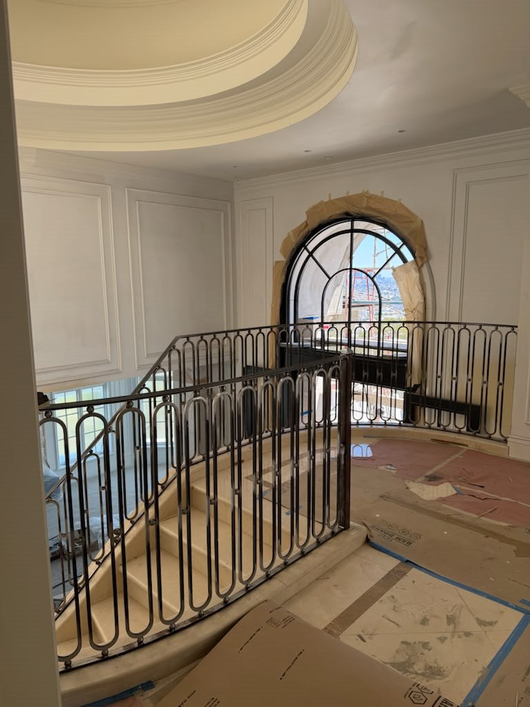 Iron staircase railing and arched window in a custom interior