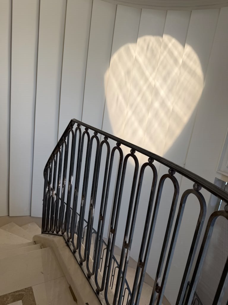 Looking down a curved staircase with custom iron railing